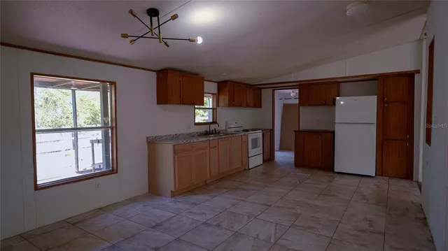 an empty room with windows and fireplace