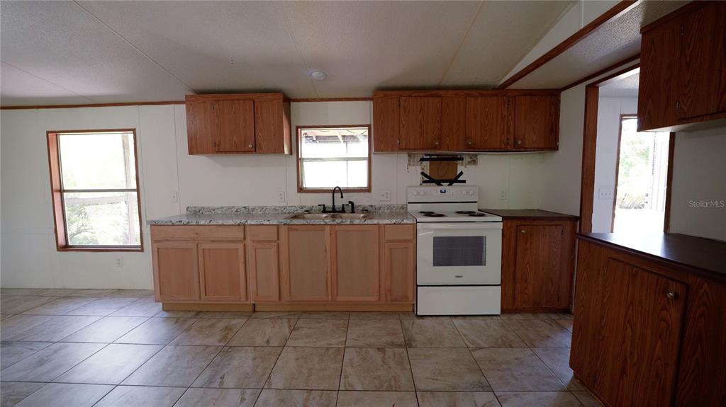 1550 East Orlando Road Orlando, FL 32820 - Photo 21 of 27 a kitchen with a stove sink and microwave