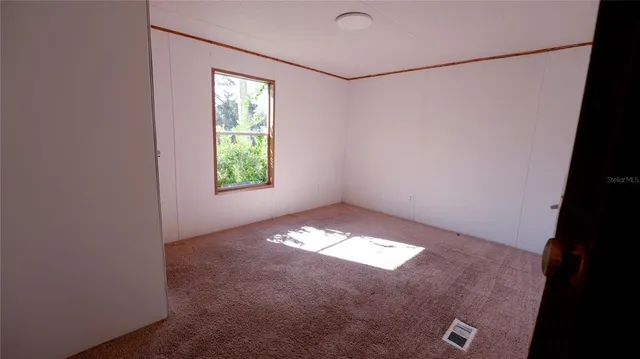 a view of empty room with a fireplace and wooden floor