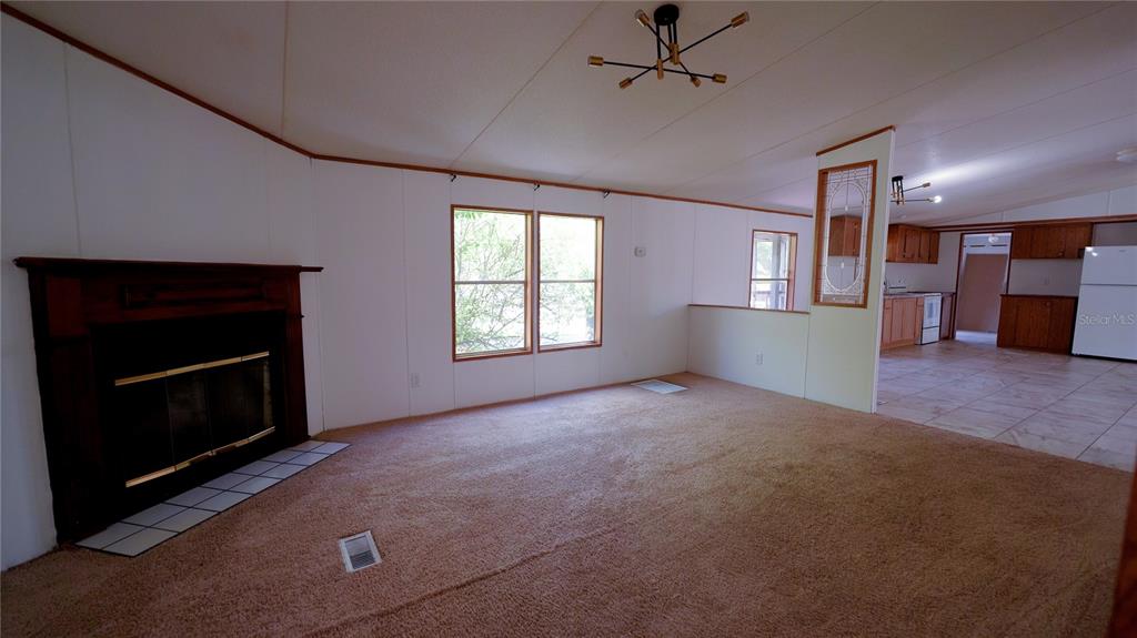1550 East Orlando Road Orlando, FL 32820 - Photo 9 of 27 a view of empty room with a fireplace and wooden floor