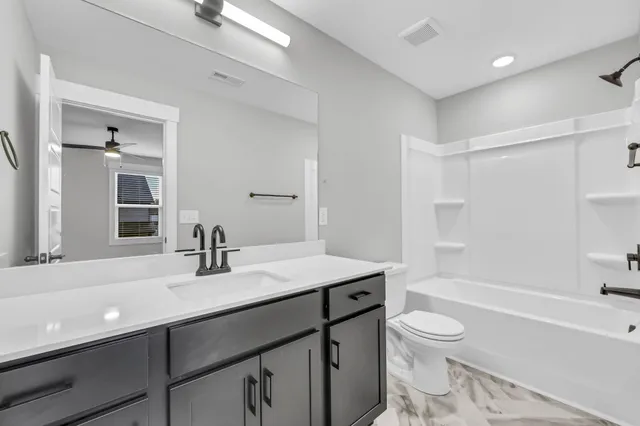 an empty room with ceiling fan and window