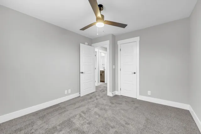 an empty room with a chandelier fan