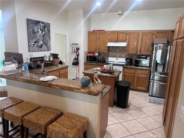 a kitchen with stainless steel appliances granite countertop a refrigerator stove and sink