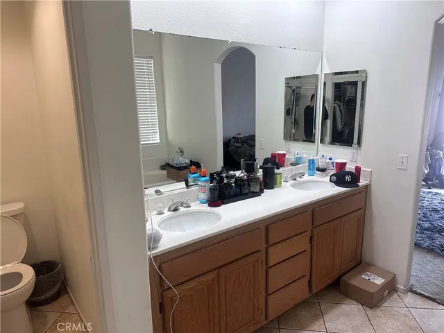 a bathroom with a double vanity sink mirror and toilet