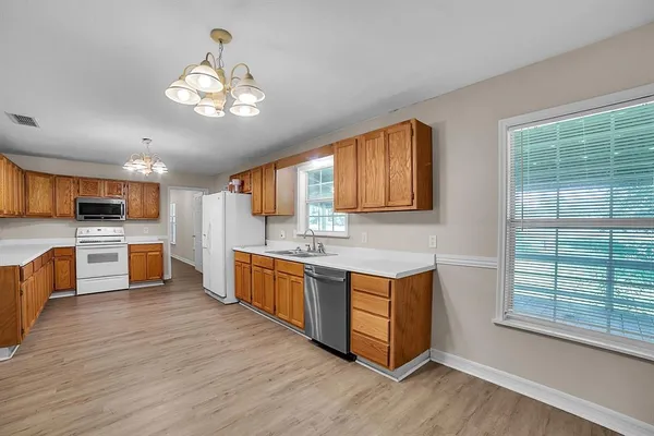 a large kitchen with stainless steel appliances granite countertop a stove and cabinets