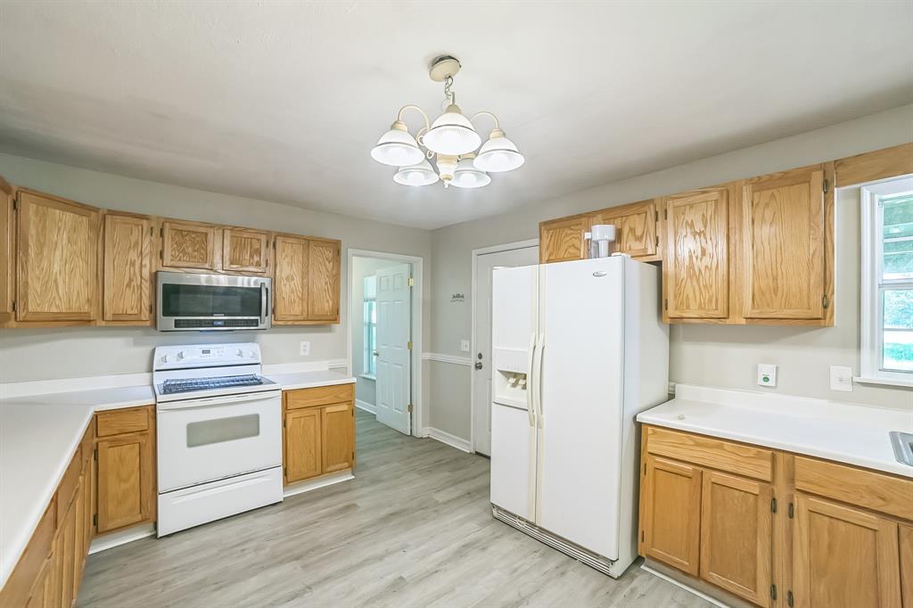 2861 Fm 727 Jefferson, TX 75657 - Photo 14 of 35 a kitchen with a refrigerator a stove top oven a sink and dishwasher with wooden floor