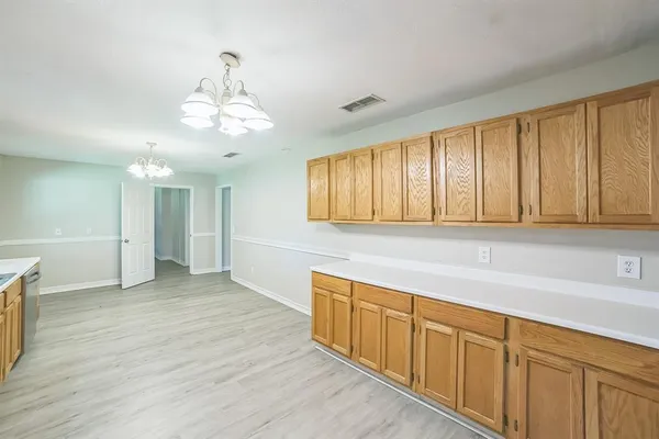 a view of a kitchen with cabinets and wooden floor