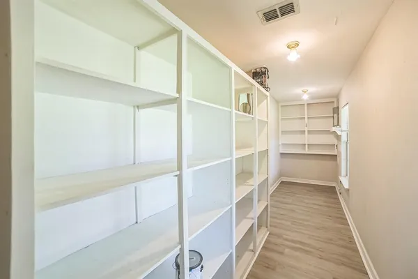 a view of walk in closet with empty racks