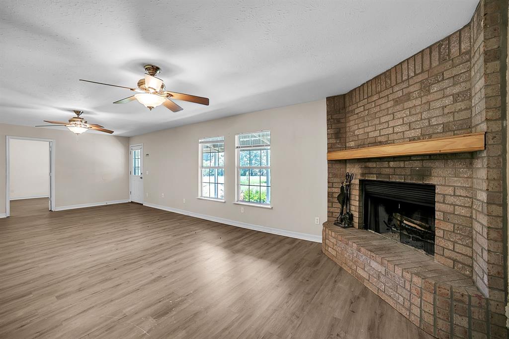 2861 Fm 727 Jefferson, TX 75657 - Photo 9 of 35 a view of a livingroom with a fireplace a chandelier and wooden floor