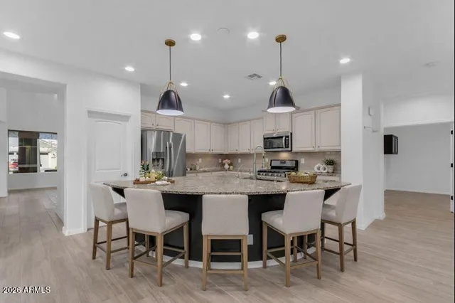 a kitchen with granite countertop white cabinets stainless steel appliances and wooden floor
