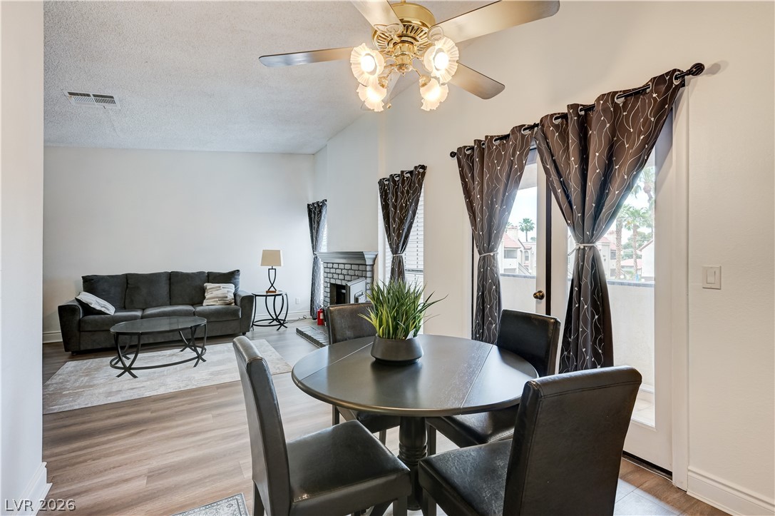 1751 East Reno Avenue, Unit 228 Las Vegas, NV 89119 - Photo 11 of 39 An inviting open-concept living space boasts a cozy fireplace and convenient outdoor access.