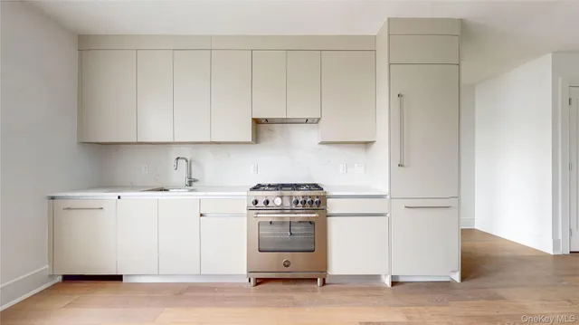 a kitchen with a stove and white cabinet