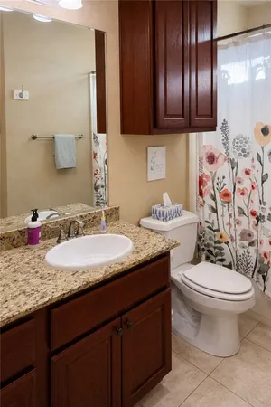 a bathroom with a granite countertop toilet sink and mirror