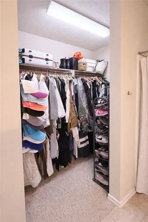 walk in closet with lots of different colored cloths