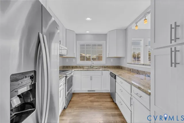 a kitchen with stainless steel appliances granite countertop a refrigerator and a stove