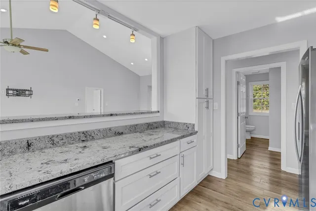 a kitchen with stainless steel appliances granite countertop a refrigerator stove and cabinets