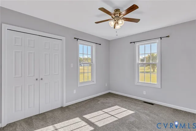 an empty room with a chandelier fan and a ceiling fan