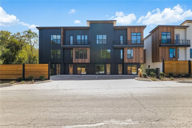 a front view of a building with retail shops and trees