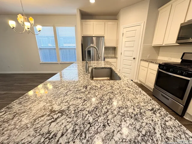 a kitchen with a stove a sink and a microwave