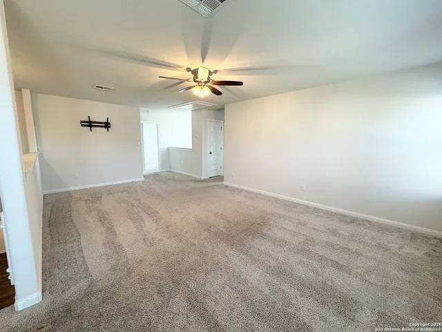 an empty room with windows and fan