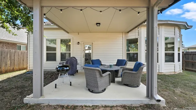 a living room with furniture a large window and potted plants