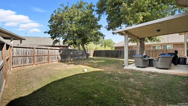a view of a patio with table and chairs a barbeque with wooden fence and roof