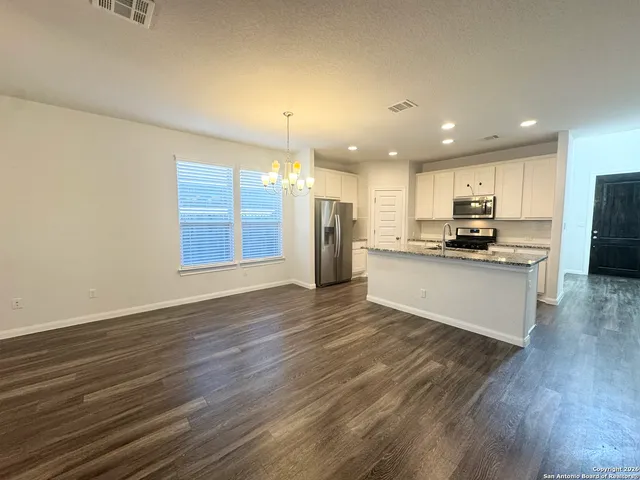 a view of kitchen with kitchen island wooden floor center island and stainless steel appliances