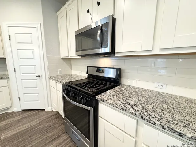 a kitchen with microwave cabinets and stove top oven