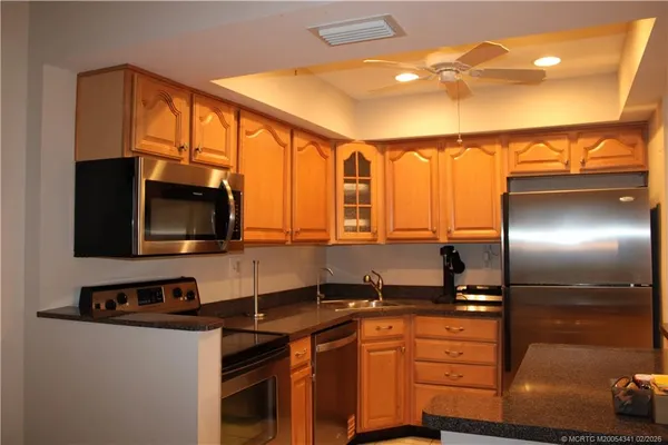 a kitchen with stainless steel appliances granite countertop a sink and a microwave