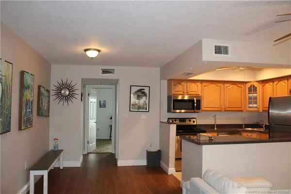 a kitchen with stainless steel appliances kitchen island granite countertop a refrigerator and a stove top oven