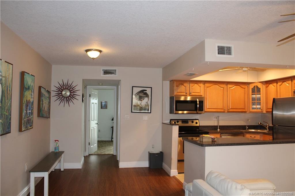 2600 South Kanner Highway, Unit G3 Stuart, FL 34994 - Photo 4 of 13 a kitchen with stainless steel appliances kitchen island granite countertop a refrigerator and a stove top oven