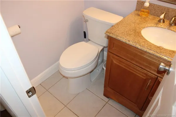 a bathroom with a granite countertop toilet and sink