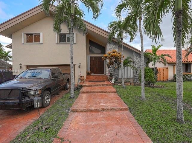 a front view of a house with a yard and potted plants