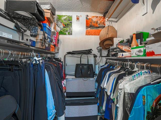 14220 Southwest 109th Street Miami, FL 33186 - Photo 26 of 30 a view of walk in closet with clothes and shoes