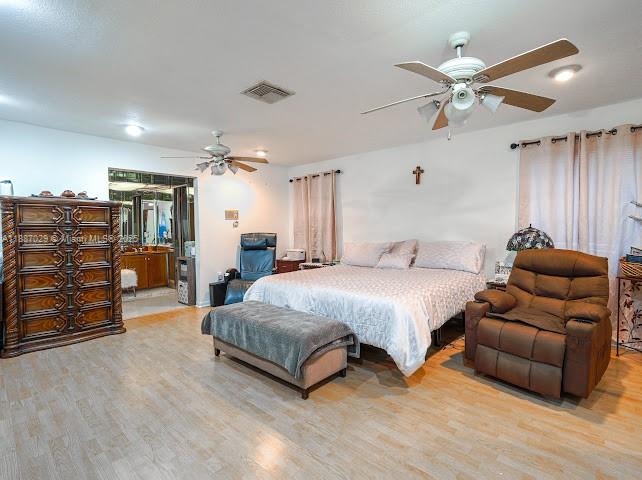 14220 Southwest 109th Street Miami, FL 33186 - Photo 28 of 30 a spacious bedroom with a bed and ceiling fan