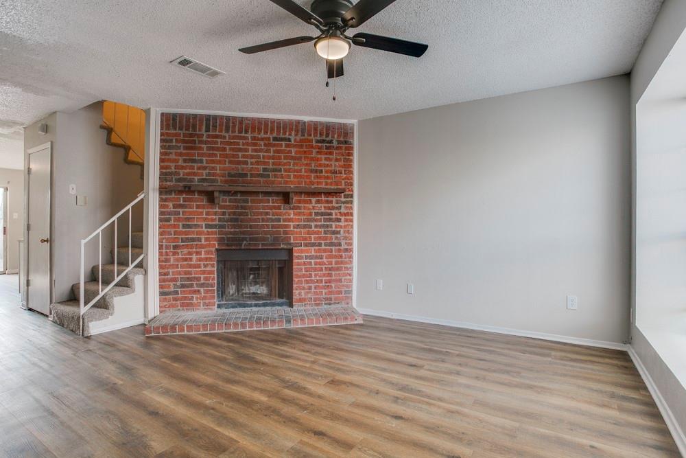 10500 Lake June Road Dallas, TX 75217 - Photo 2 of 11 a view of an empty room with wooden floor a ceiling fan and windows
