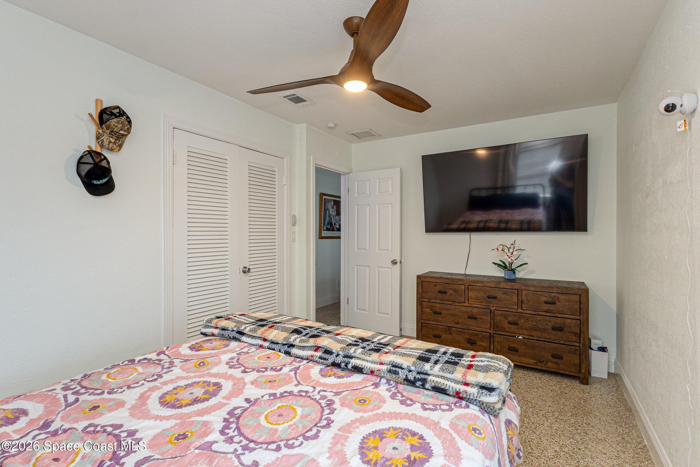131 Delmar Street Indialantic, FL 32903 - Photo 16 of 29 a bedroom with a bed and a flat screen tv