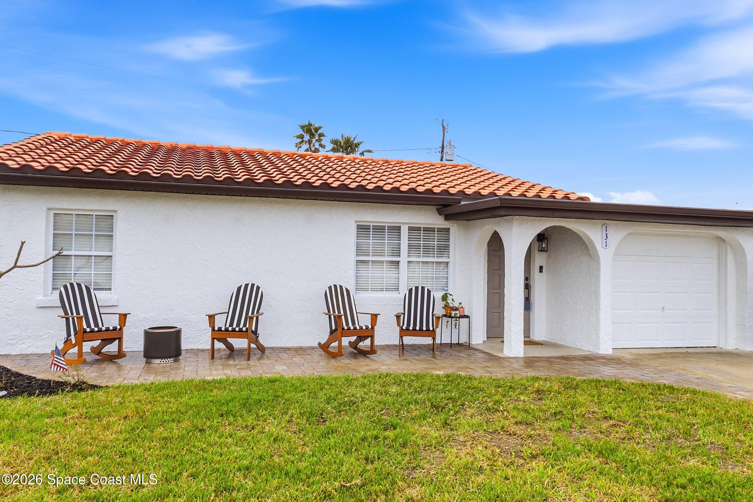 131 Delmar Street Indialantic, FL 32903 - Photo 21 of 29 a view of a patio with table and chairs potted plants and a large tree