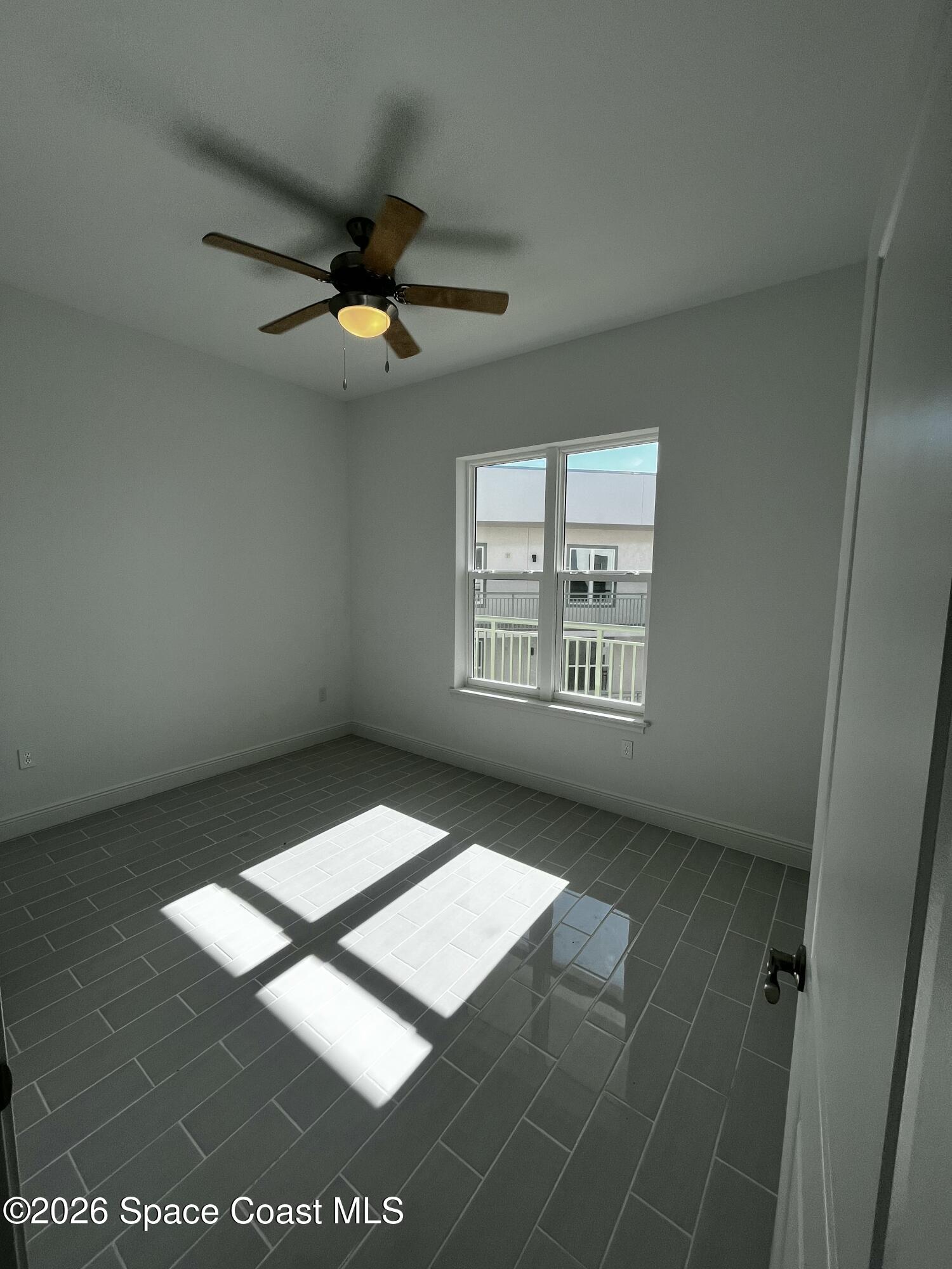 735 Pilot Lane, Unit 503 Merritt Island, FL 32952 - Photo 7 of 26 a view of an empty room with window and a ceiling fan