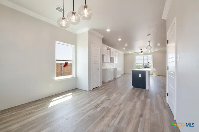 a open kitchen with kitchen island white cabinets and stainless steel appliances