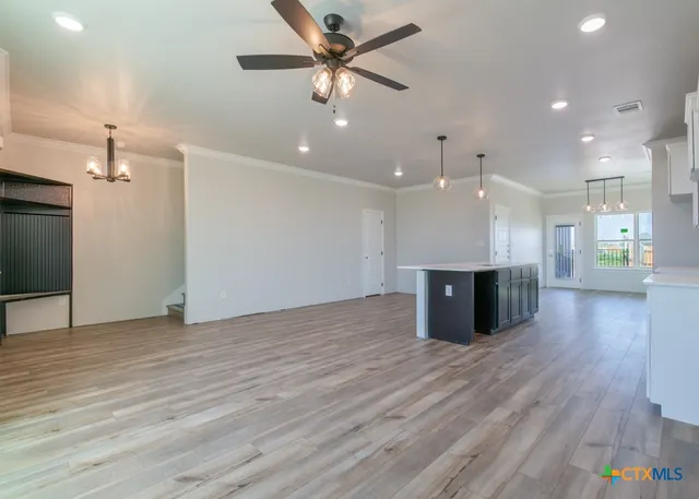 wooden floor in an empty room with a kitchen