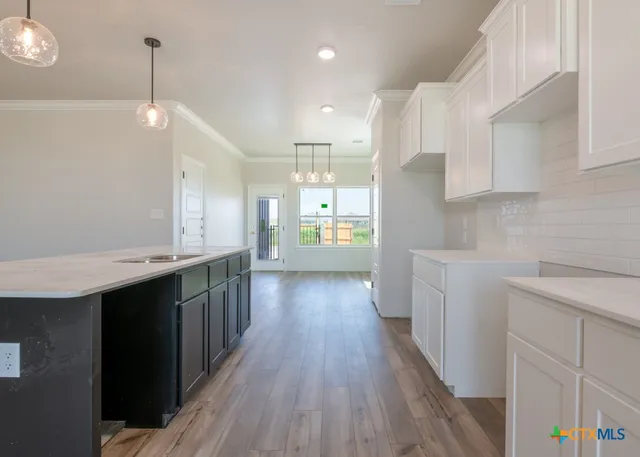 a kitchen with counter top space and wooden floor