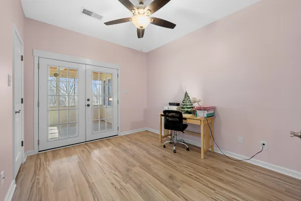 a view of a workspace with wooden floor and a window
