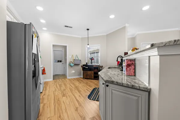 a very nice looking kitchen with granite countertop a refrigerator and a stove