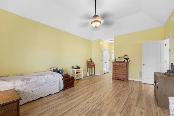 a bedroom with a bed and wooden floor
