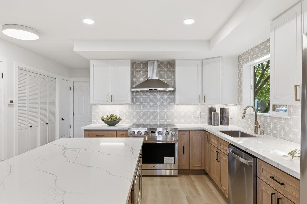 370 Burning Tree Court Half Moon Bay, CA 94019 - Photo 11 of 47 a large white kitchen with stainless steel appliances granite countertop a stove and a sink