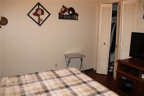 a bedroom with a bed and a flat tv screen on a dresser