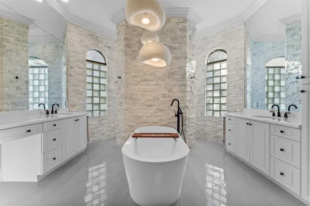 a bathroom with a double vanity sink a mirror a bathtub and window