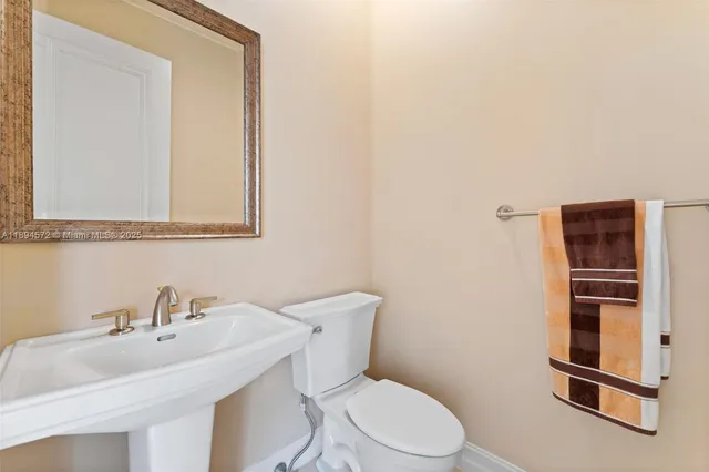 a bathroom with a sink a toilet and mirror