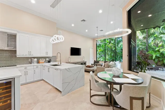 a view of kitchen with stainless steel appliances kitchen island granite countertop a table and chairs in it